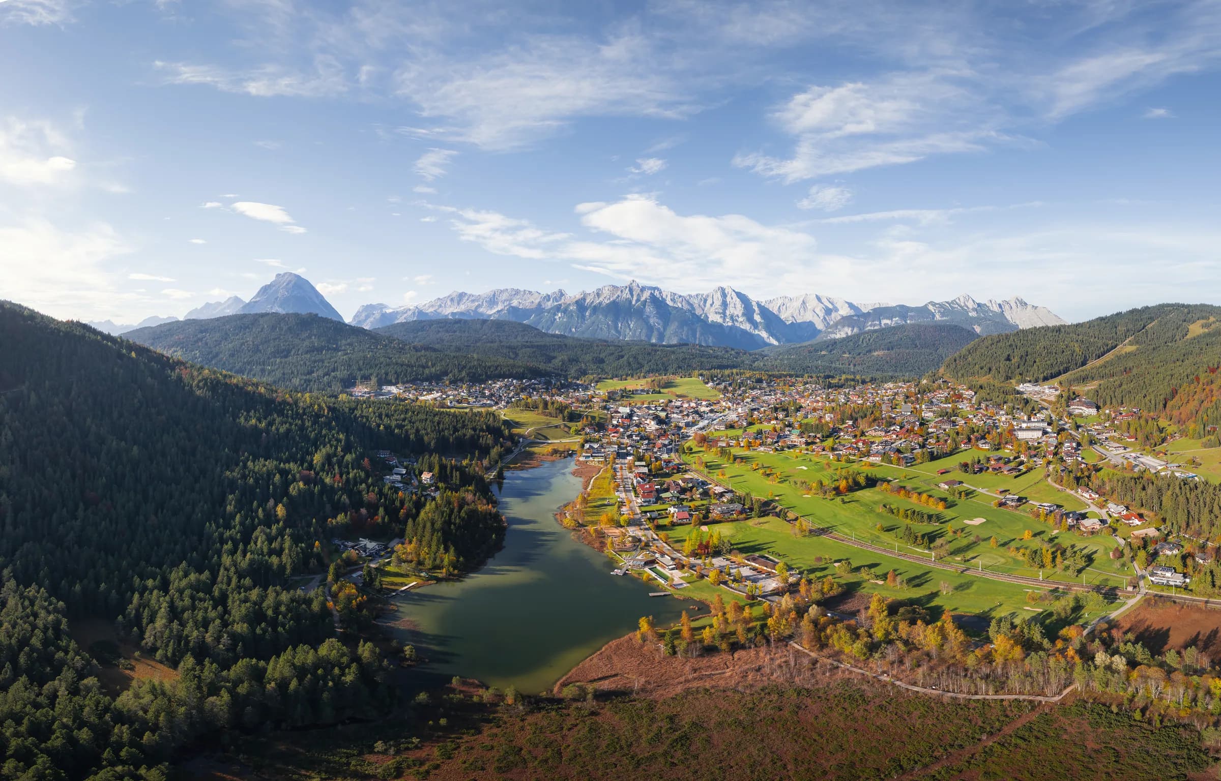 Panorama-Drohnenaufnahme des Wildsees und des Golfplatzes Wildmoos in Herbstfarben